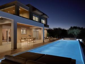 a house with a swimming pool in front of a house at Hora Ionica Villa, Private Pool & 10acre GreenLand, By ThinkVilla in Koukounariá