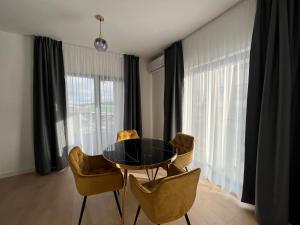 a dining room with a black table and chairs at Exit Aparthotel in Floreşti