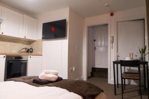 a bedroom with a bed and a kitchen with a table at Studio apartment - The Topaz 