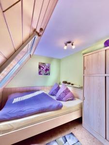 a bedroom with a bed with purple pillows at Haus am Berg 2 in Neuenkirchen