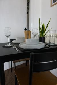 a black table with a plate and glasses on it at Studio apartment - The Topaz 