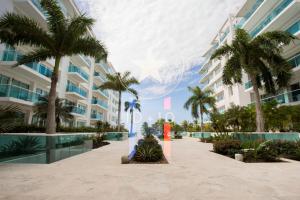 Condominio frente al mar con acceso directo a la playa Morros 922 في كارتاهينا دي اندياس: مبنى كبير أمامه أشجار نخيل