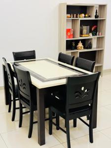 - une table à manger noire avec des chaises noires dans l'établissement Maxwell Merpati Taiping Homestay, à Kamunting