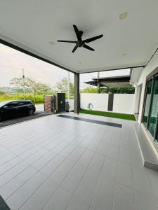 - un garage avec un ventilateur de plafond et une voiture dans l'établissement Maxwell Merpati Taiping Homestay, à Kamunting