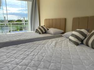 a bedroom with two beds and a large window at Recanto Casa de Itaúna in Saquarema +111 photos