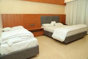 a hotel room with two beds in a room at Hotel Sai D-lax in Shirdi