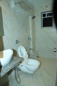 a bathroom with a white toilet and a sink at Hotel Sai D-lax in Shirdi