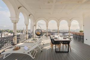 d'un balcon avec une table et des chaises. dans l'établissement The most Exclusive apartment in Sevillaparking, à Séville