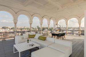 - un salon avec un canapé et une table sur un balcon dans l'établissement The most Exclusive apartment in Sevillaparking, à Séville