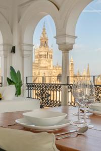 - une table avec des assiettes et des verres à vin sur un balcon dans l'établissement The most Exclusive apartment in Sevillaparking, à Séville