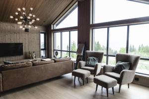 sala de estar con sofá, sillas y ventanas en Chill cabin - fantastic view and nice hiking area, en Aurdal