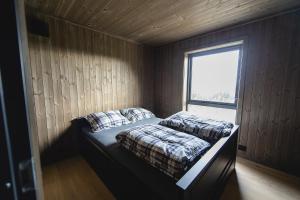 a small bedroom with a bed with a window at Chill cabin - fantastic view and nice hiking area in Aurdal