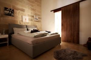 una camera con letto e muro di mattoni di Luxury House of Character Golden Bay/Manikata. a Ix-Xagħra l-Ħamra