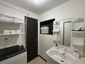 Un baño pequeño con lavabo y espejo. en 舒心云舍, en Osaka 25 fotos más