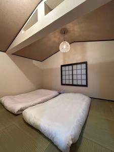 2 camas en una habitación con techo en 舒心云舍, en Osaka