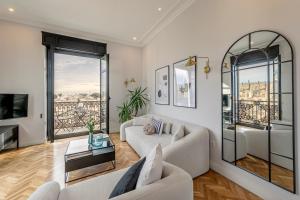 Il comprend un salon doté d'un mobilier blanc et d'un balcon. dans l'établissement The most Exclusive apartment in Sevillaparking, à Séville