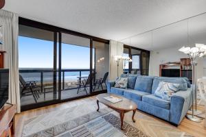 ein Wohnzimmer mit einem blauen Sofa und großen Fenstern in der Unterkunft Golden Sands IV in Ocean City