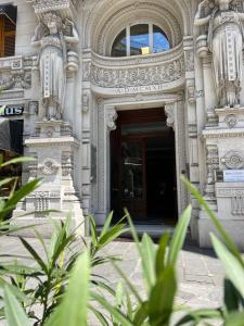 una entrada a un edificio con estatuas en él en Hotel Genova Liberty en Génova