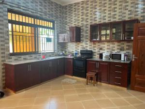 a kitchen with wooden cabinets and a stove top oven at J & S LUGALLA HOUSE in Dar es Salaam