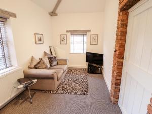 a living room with a couch and a tv at The Nest in Doncaster