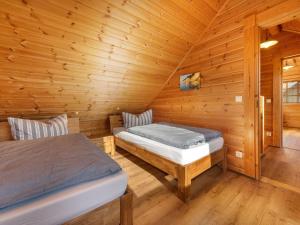 ザスニッツにあるBlockhausferien Rügen - Meerblickの木造キャビン内のベッドルーム1室(ベッド2台付)