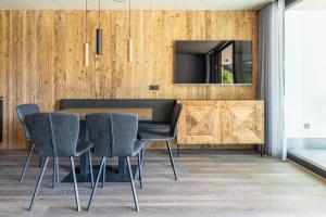 a dining room with a table and chairs and a television at Köfele Lodge Sepp in Parcines