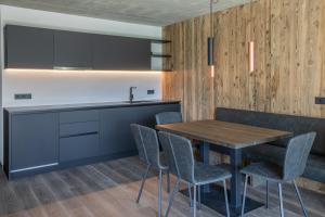 a kitchen and dining room with a wooden table and chairs at Köfele Lodge Sepp in Parcines +4 photos