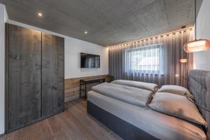 a bedroom with a large bed and a window at Köfele Lodge Sepp in Parcines