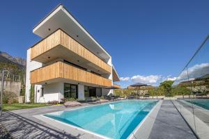 a building with a swimming pool in front of it at Köfele Lodge Agnes in Parcines