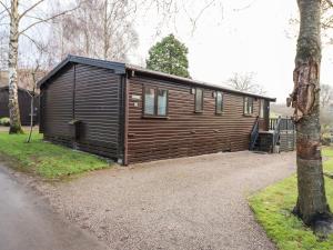 a wooden cabin in a yard with a tree at Latrigg Lodge in Keswick
