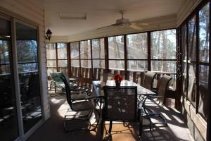 a screened in porch with a table and chairs at Aunt Pattie's Lake House in Fairfield Bay