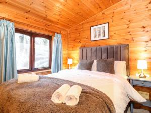 a bedroom with a large bed in a log cabin at Latrigg Lodge in Keswick