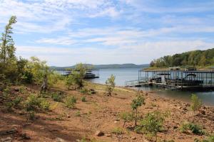 a dock on a lake with two boats in the water at Aunt Pattie's Lake House in Fairfield Bay