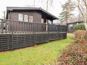 a house with a fence in front of it at Latrigg Lodge in Keswick