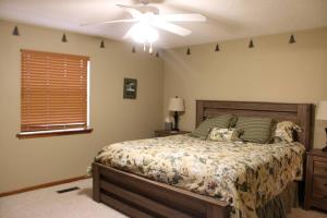 a bedroom with a bed and a ceiling fan at Aunt Pattie's Lake House in Fairfield Bay