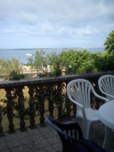 two chairs and a table on a balcony overlooking the ocean at Holiday Home Pavica in Vrsi