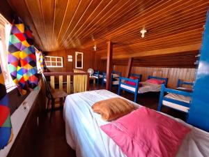 a bedroom with a bed and chairs in a room at La Musica Hostel OuroPreto in Ouro Preto