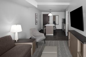 a living room with a couch and a tv in a room at Hyatt House Lansing-University Area in Lansing