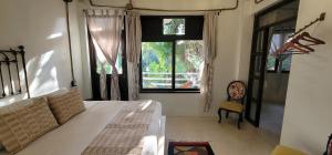 a bedroom with a bed and a large window at Casa Ambar Tulum - Great Location in Tulum