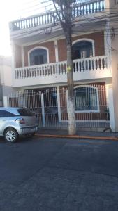 een auto geparkeerd voor een huis met een hek bij voltamos a funcionar casa da mãe Aparecida in Aparecida