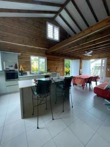 cocina y sala de estar con mesa y sillas en VILLA -Le Chalet Tropical, en Le Marin