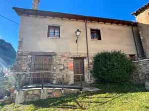 una antigua casa de piedra con dos ventanas y una puerta en Moradas Busdongo, 