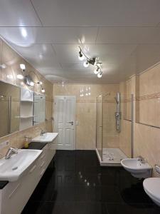 ein Bad mit 2 Waschbecken und einer Dusche in der Unterkunft Apartment - Pension Marianna in Rust
