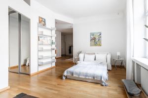 a white bedroom with a bed and a mirror at Cozy, spacious and calm apartment central Helsinki in Helsinki