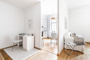 a white living room with a desk and a chair at Cozy, spacious and calm apartment central Helsinki in Helsinki