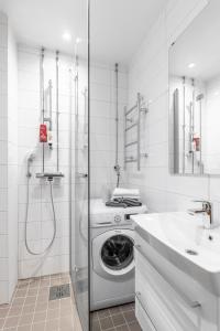 Cozy, spacious and calm city home - top location في هلسنكي: حمام ابيض مع غسالة ومغسلة