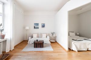 Habitación blanca con 2 camas y espejo. en Cozy, spacious and calm city home - top location en Helsinki