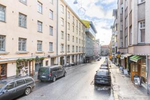 una calle de la ciudad con coches y edificios aparcados en Cozy, spacious and calm city home - top location en Helsinki