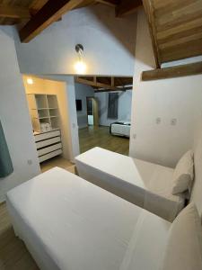 1 Schlafzimmer mit 2 weißen Betten in einem Zimmer in der Unterkunft Pousada Ilha da Magia in Florianópolis