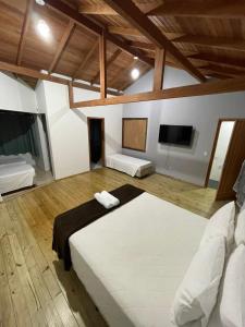 Habitación grande con cama y TV de pantalla plana. en Pousada Ilha da Magia, en Florianópolis